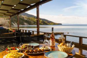 a table with plates of food and a bottle of wine at Levantino Studios & Apartments in Vasilikos
