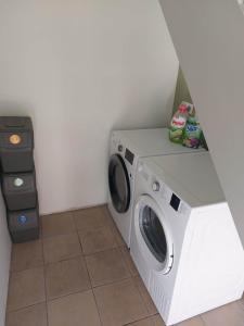 una lavadora y secadora en una esquina de una habitación en Ô Baguenaudes, en Jalhay