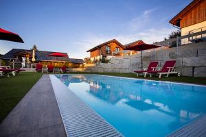 una piscina con sillas rojas y un edificio en Chaletpark Diemelsee, en Heringhausen