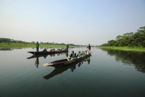 a group of people in boats on a river at Kasara Chitwan in Chitwan