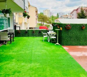 dziedziniec z zieloną trawą, stołem i krzesłami w obiekcie Lucky Homes w mieście Ankara