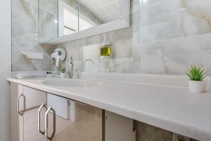 a white bathroom with a sink and a mirror at Lucky Homes in Ankara
