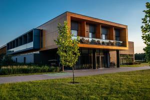 a building with a tree in front of it at Hotel Bonifacio SPA&SPORT Resort in Sochocin