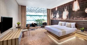 a bedroom with a bed and a flat screen tv at FM7 Resort Hotel - Jakarta Airport in Tangerang