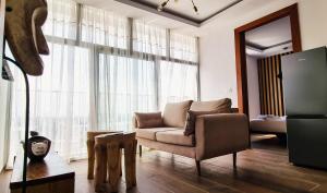 a living room with a couch and a large window at Signal Appartments in Abidjan