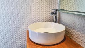 a white sink in a bathroom with a faucet at Signal Appartments in Abidjan +17 photos