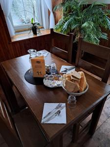 a table with a bowl of bread and a plate of food at Pension U Johnů in Petrovice