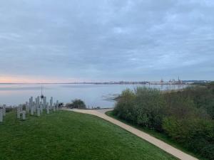 a path next to a body of water with a bridge at Sea View Penthouse Marina Apartment in Portishead