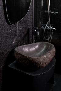 a bathroom with a large stone sink on a counter at Theros by Agora Luxury Apartments in the heart of Heraklion in Heraklio Town