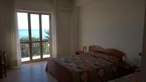 ein Schlafzimmer mit einem Bett und einem großen Fenster in der Unterkunft Hotel Panama in Ardore Marina