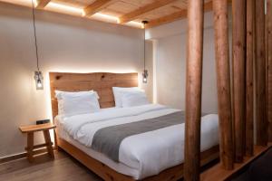 a bedroom with a large bed with wooden posts at Theros by Agora Luxury Apartments in the heart of Heraklion in Heraklio Town