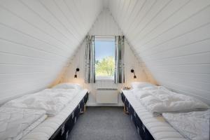 three beds in a room with a window at Lalandia Rødby in Rødby