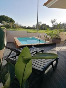 un patio con piscina y una terraza con sillas en Vivenda Geminada com piscina a 10 minutos a pé da praia, en Portimão