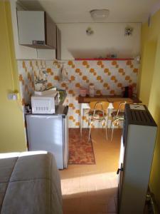 a kitchen with a refrigerator and a table with chairs at B&B LA MARMOTTA in Coazze
