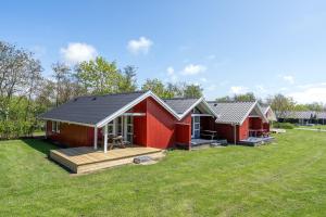 una fila de cabañas rojas en un patio en Lalandia Rødby en Rødby