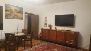 a living room with a table and a flat screen tv at Casa Soarelui in Roşu