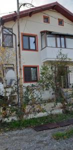 une maison blanche avec des fenêtres rouges et une clôture dans l'établissement Casa Soarelui, à Roşu