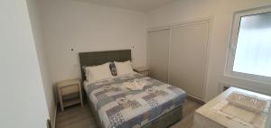 ein kleines Schlafzimmer mit einem Bett und einem Fenster in der Unterkunft ACR Holiday Apartment in Quarteira