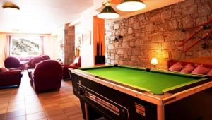 a room with a pool table and a brick wall at Chalet JL et DS , Pied des pistes, Valmeinier 1800, 10 pers. in Valmeinier