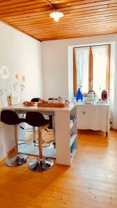 una cucina con tavolo e due sgabelli in una stanza di in lak'ech - rooms a Chironico