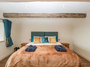 a bedroom with a large bed with blue pillows at Palace Farmhouse in Hereford