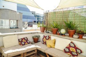 a couch sitting on a balcony with pillows at Tamaran House in Las Palmas de Gran Canaria