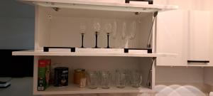 a shelf with wine glasses on it at J. Kuperjanov Apartment in Tartu