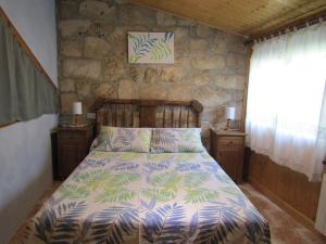 Un dormitorio con una cama y una pared de piedra. en Casa Burgués, en Beceite