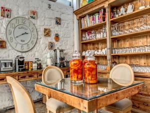 a table with chairs and a clock on the wall at Beyevi Alaçatı in Alaçatı