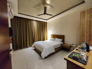 a hotel room with a bed and a desk with aention at Hotel Hibiscus Tree- Bachupally in Hyderabad +21 photos