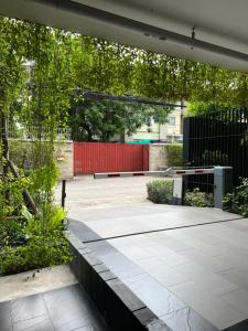 a courtyard with a bench and a red fence at The Remarkable ศูนย์วิจัย2 in Bangkok