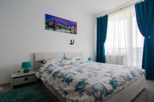 a bedroom with a bed and a window with blue curtains at Azure Home in Cluj-Napoca