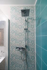 a shower with a hose in a bathroom at Azure Home in Cluj-Napoca