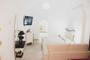 un soggiorno bianco con divano e specchio di Acasadifelice a Matera