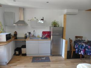 a kitchen with a stainless steel refrigerator and a sink at Maison de village au calme axe Annecy - Genève in Villy-le-Pelloux