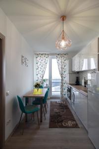 a kitchen with a table and chairs and a dining room at Azure Home in Cluj-Napoca