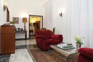 a living room with a red chair and a table at Houspitality Caesar Bed & Breakfast in Rome