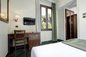 a bedroom with a bed and a desk and a television at Grand Hotel Gianicolo in Rome