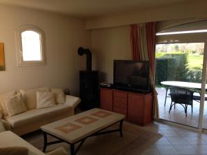 a living room with a couch and a tv at Villa Royal Mougins Golf Club in Mougins