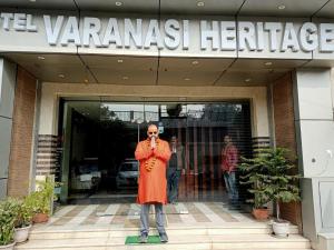 a man standing in front of a building at Hotel Varanasi Heritage in Varanasi