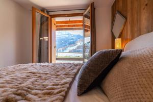 sypialnia z łóżkiem i widokiem na góry w obiekcie Appartement Abela 10 Pers Domaine de Serre Chevalier w mieście Saint-Chaffrey