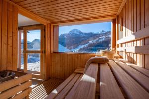 Pokój z dużym oknem w drewnianym domku w obiekcie Appartement Abela 10 Pers Domaine de Serre Chevalier w mieście Saint-Chaffrey