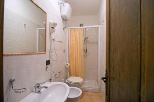 a bathroom with a sink and a toilet and a mirror at Agriturismo La Fattoria in Ascea +61 photos