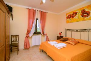a bedroom with an orange bed with towels on it at Agriturismo La Fattoria in Ascea +38 photos