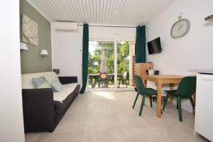 a living room with a couch and a table at Le Champ d'Eysson Aparthotel in Montauroux