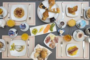 a table with plates of breakfast foods and drinks at Grand Hotel Gianicolo in Rome