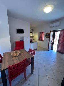 a kitchen and dining room with a table and chairs at Trilocale climatizzato con cortile in San Teodoro