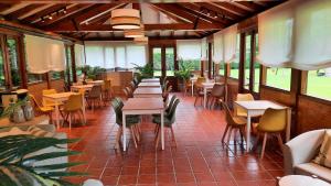 a restaurant with tables and chairs and windows at Apartamentos Camin De Pelayo in Las Rozas