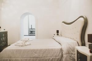 Un dormitorio blanco con una cama con toallas. en Acasadifelice en Matera