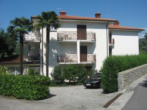 a white house with a car parked in front of it at B&B Kovač in Portorož